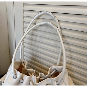 Close-up of the drawstring closure and silver eyelets on this white leather tote bag