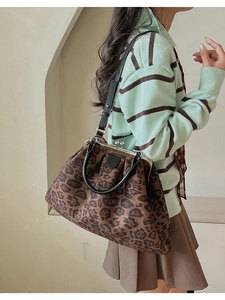 Détail d'un sac cabas léopard avec fermoir métallique vintage et anses en cuir