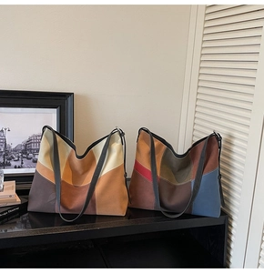 Close-up of dual oversized tote bags featuring geometric patchwork in diverse color blocks