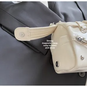 Detail shot of a soft leather crossbody bag showing the magnetic buckle and zipper closure