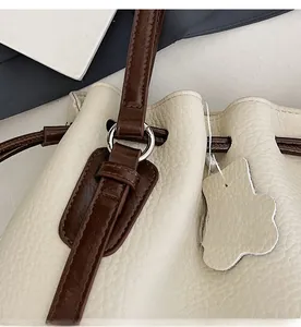 Detail of lychee pattern leather tote with premium silver metal ring and contrast strap