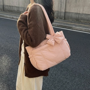 Quilted light pink puff tote bag with oversized bow detail, street style fashion look