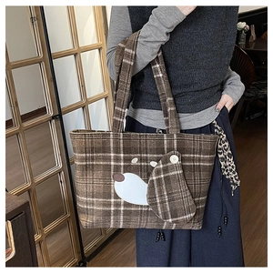 Dettaglio della borsa tote a quadri marroni con patch animale cartoon e orecchio in 3D