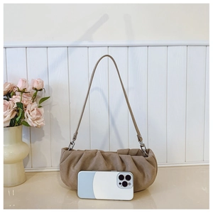 Khaki pleated cloud bag detail showing matte suede texture and size compared to a phone
