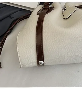 Detail of metal rivets on the bottom of a cream leather tote bag for durability