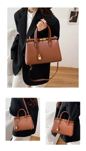 Detail view of caramel trapezoid handbag with gold bar lock and decorative gold padlock