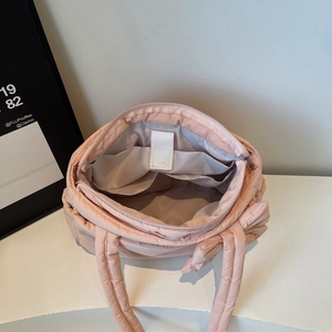Pink quilted puffer tote bag with interior pockets and cute bow detail on the handle