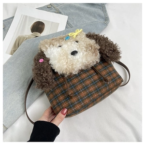 Dettaglio di decoro cucciolo di peluche su borsa a quadri marroni con tracolla