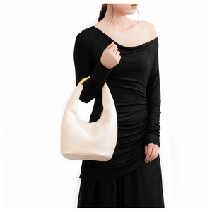 Dettaglio del moderno manico in metallo dorato e borsa hobo in pelle beige crema chic
