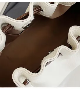 Detail of premium silver magnetic closure on white lychee leather tote bag interior