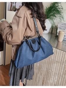 Détail du sac à main en denim bleu avec lanières en cuir noir et fermoir métallique