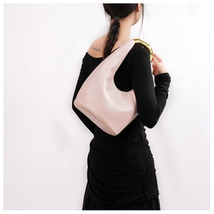 Dettaglio borsa hobo in pelle rosa con manico ad anello in metallo dorato effetto bambù