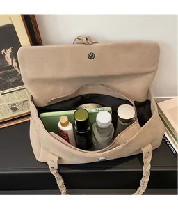 Vista interna della grande borsa tote in pelle scamosciata con manico intrecciato