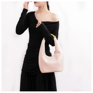 Dettaglio della borsa in pelle rosa chiaro con elegante manico circolare in metallo