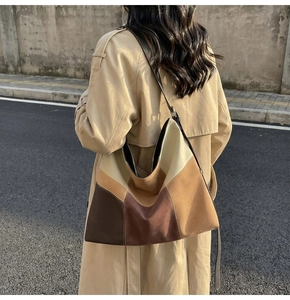 Outdoor shot of a large patchwork suede tote bag with contrast stitching and long strap