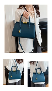 Detail of dark blue leather handbag with gold hardware locks and versatile strap styles