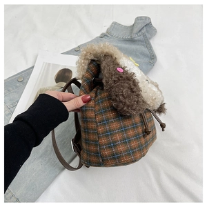 Dettagli in peluche a forma di cane su uno zaino a quadri marroni con lacci in pelle eleganti