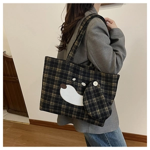 Vista laterale della borsa tote a scacchi con patch a cane indossata a spalla da modella