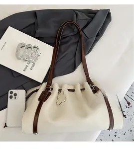 Detail view of off-white lychee texture tote bag with brown straps and drawstring