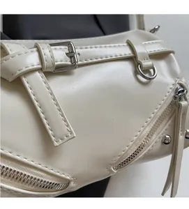 Detailed close-up of off-white faux leather texture with silver metal buckle and zipper