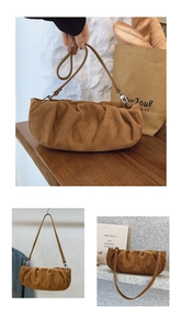 Detailed view of brown suede cloud bag with pleated texture and thin shoulder strap