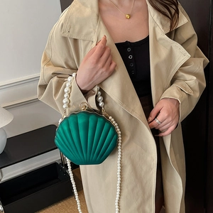 Green shell-shaped acrylic evening bag with pearl bead handle and shoulder strap