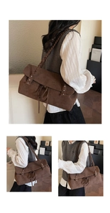 Dettaglio borsa tote in pelle scamosciata marrone scuro con tracolla intrecciata e fiocco