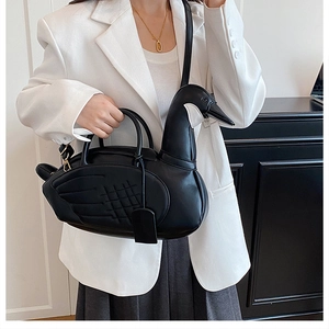 Détail du sac à main noir en forme de cygne avec surpiqûres d'ailes et bandoulière réglable