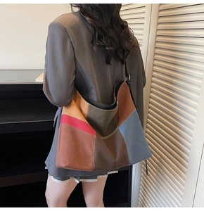 Detail of color-block patchwork tote bag featuring decorative white contrast stitching