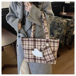 Dettaglio della borsa shopper a scacchi con toppa cane 3D e bottone decorativo