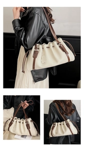 Detail of off-white pleated bucket bag with lychee texture and brown leather strap