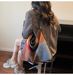 Detailed view of oversized patchwork tote bag in vibrant suede leather on model