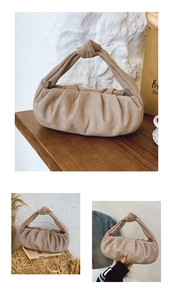 Detail view of khaki pleated dumpling bag with textured matte finish and knotted handle