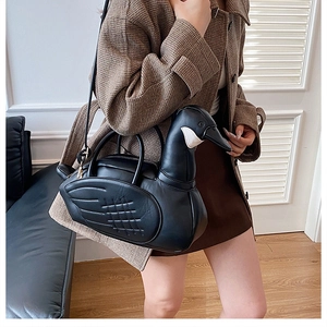 Sac à bandoulière en forme de cygne noir porté comme accessoire de mode élégant