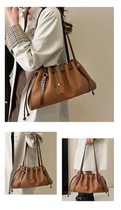 Macro view of brown pleated tote bag with drawstring closure and cute bear charm detail
