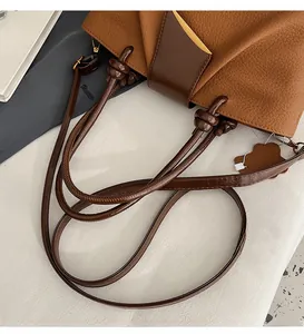 Close-up of adjustable shoulder strap and textured lychee pattern on brown tote bag