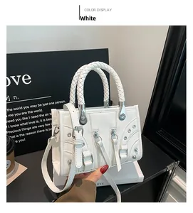 Detailed shot of a white punk style baguette bag with rivets and braided handle
