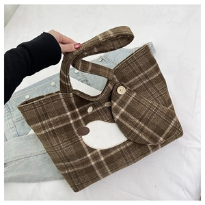 Dettaglio della borsa tote a quadri marroni con mini pochette e decorazione applicata