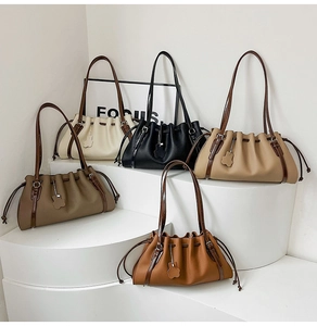 Detail shot of five color options for drawstring bucket bags with floral charms
