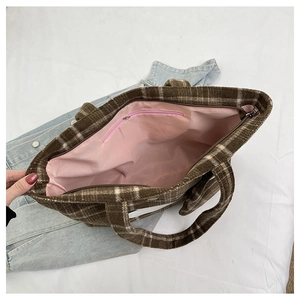 Interno della borsa tote a quadri marroni con fodera rosa e tasca con cerniera