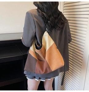 Detail view of large patchwork tote bag featuring vintage brown and khaki color blocking