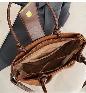 Interior detail of brown faux leather handbag showing zippered pockets and compartments