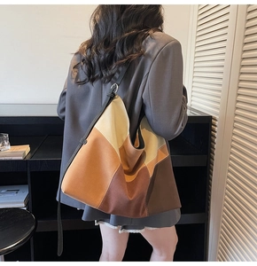 Close-up of a large color-block patchwork tote bag featuring neutral earth tones and strap