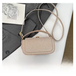 Close-up of champagne woven box bag texture with handle on white surface