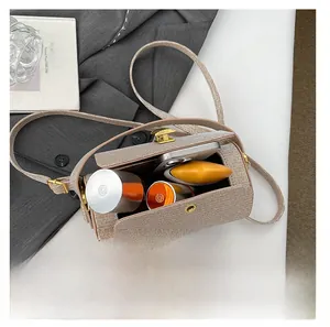 Top view of cylinder shoulder bag showing interior space for phone and makeup items
