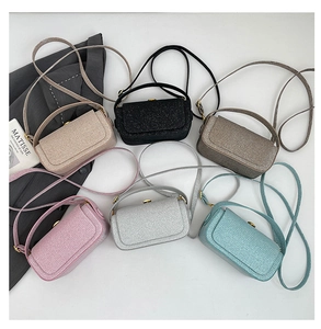 Flat lay of six colorful glitter mini crossbody bags with metallic finish and magnetic snap