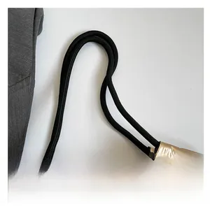 Detail of black braided handles connected to the gold metallic star puffer tote bag