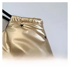 Macro shot of gold quilted fabric with black star print and textile straps on a tote