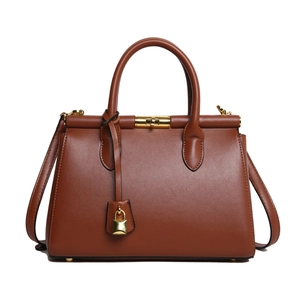 Brown vintage leather handbag with gold hardware and adjustable strap on white background