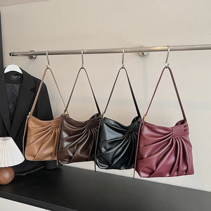 Pleated PU leather tote bags in four vintage colors hanging on a modern display rack
